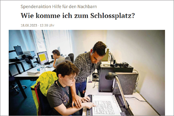 Vorschaubild Artikel mit der Überschrift "Wie komme ich zum Schlossplatz?" und Foto auf dem ein junger Mann vor dem Tactonom Reader sitzt. Neben ihm steht ein Mann.