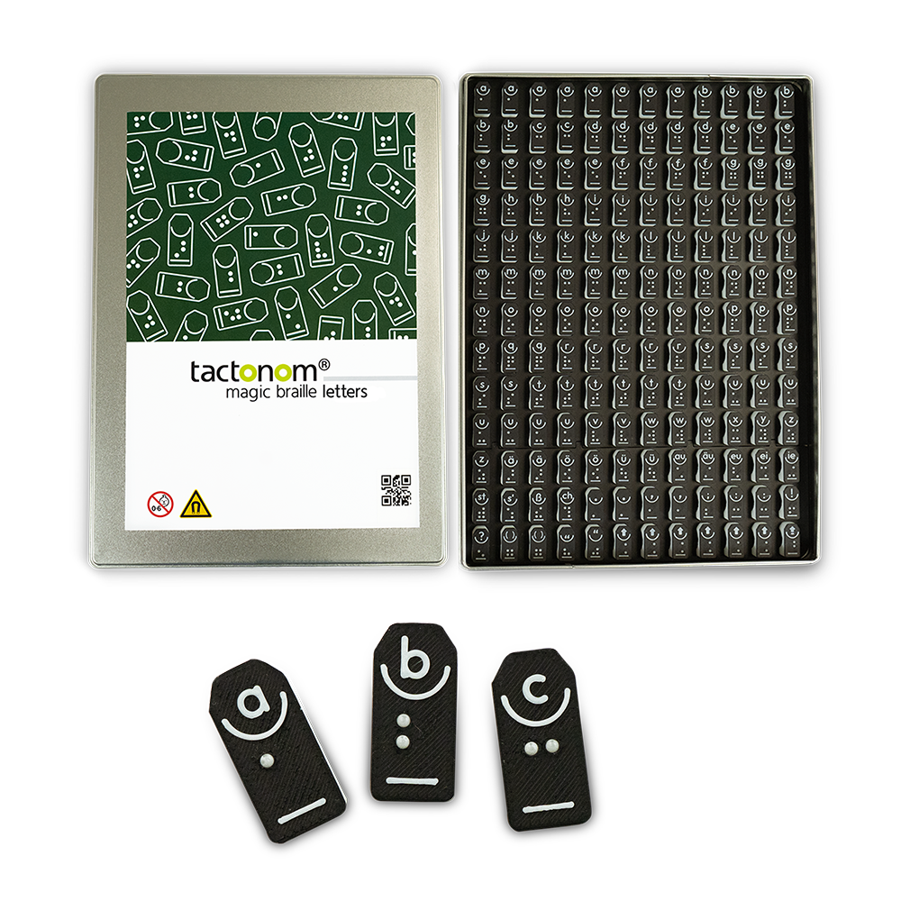Das Foto zeigt die offene Box der Tactonom Magic Braille letters. Die Braille-Steine für "a", "b" und "c" sind noch einmal stark vergrößert darunter abgebildet.